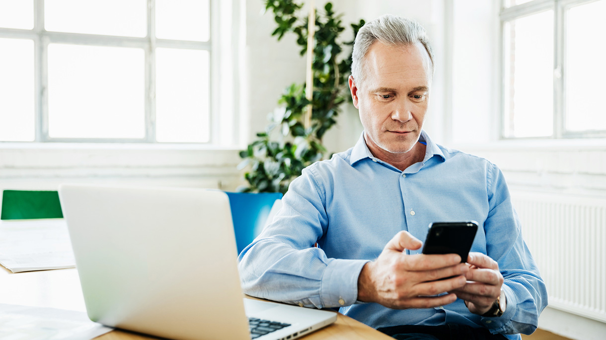 Office Manager Using Smartphone And Laptop