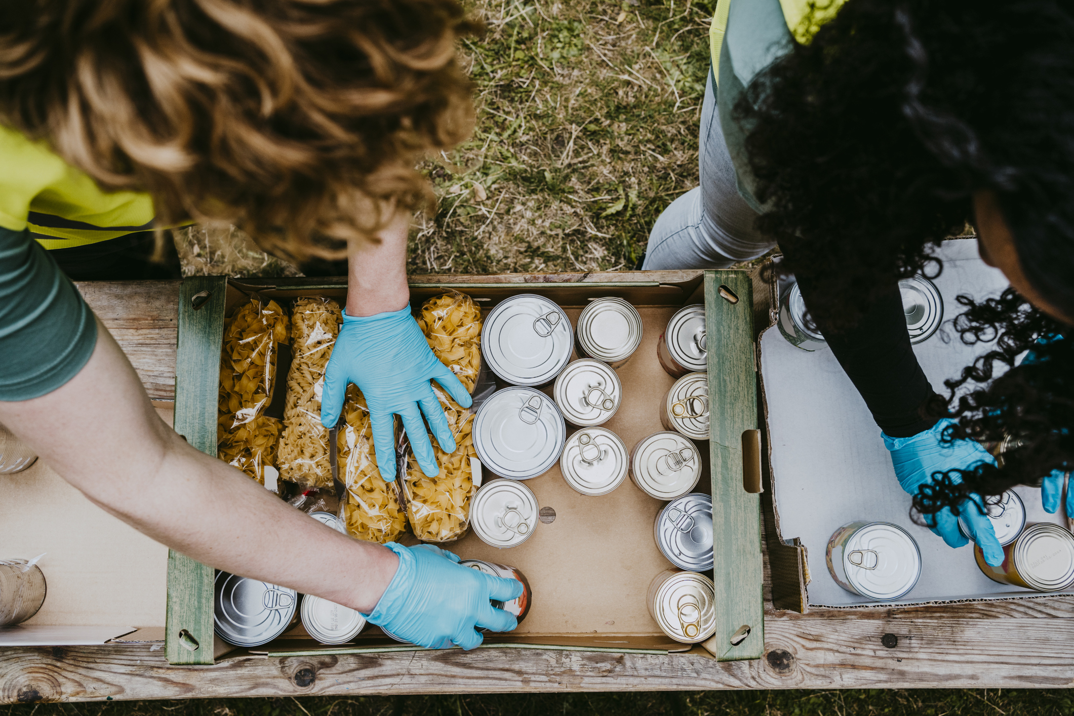 Male and female friends arranging food in cardboard boxes
