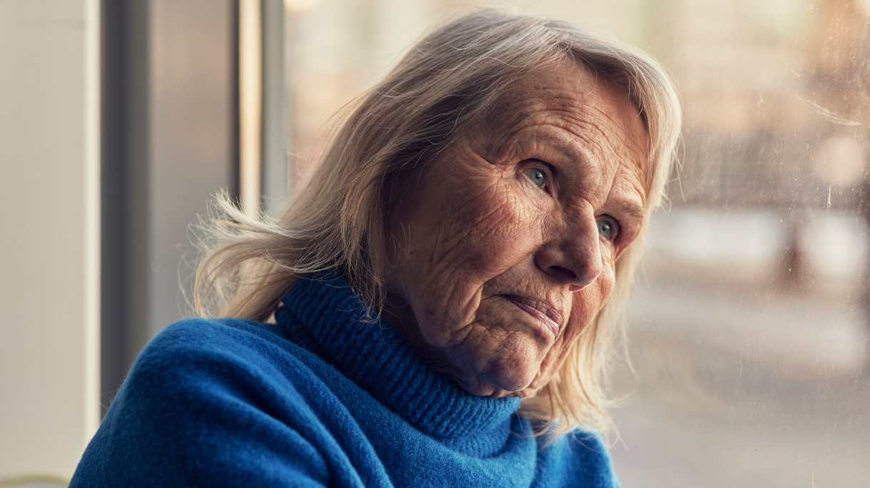 Vrouw kijkt zorgelijk naar buiten