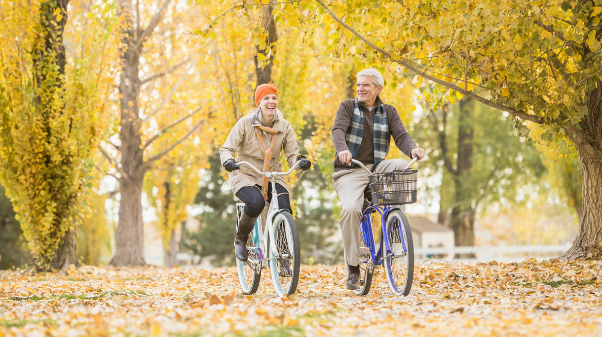 Fietsende mensen in een herfstbos