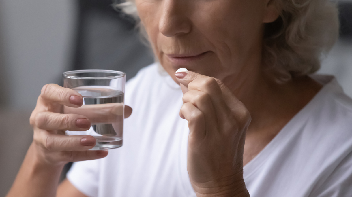Vrouw slikt pijnstiller