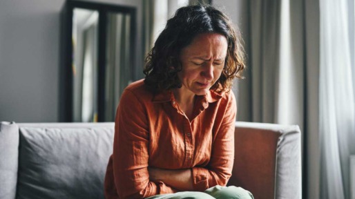 Vrouw met buikpijn op de bank