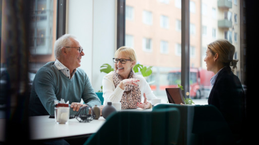Smiling senior couple talking while sitting with realtor in office