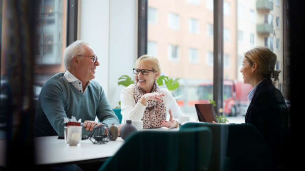 Smiling senior couple talking while sitting with realtor in office