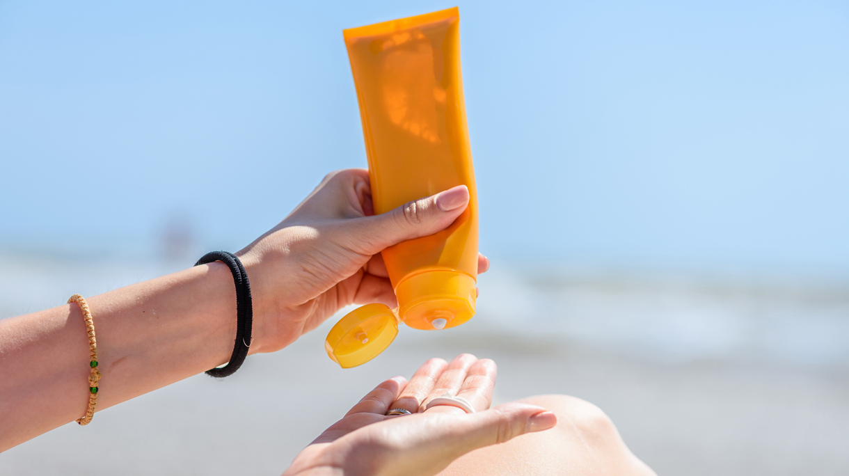 Vrouw smeert zich in met zonnebrandcreme op het strand