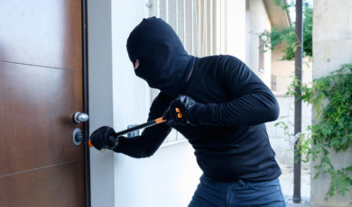 Burglar trying to force a door lock using a crowbar