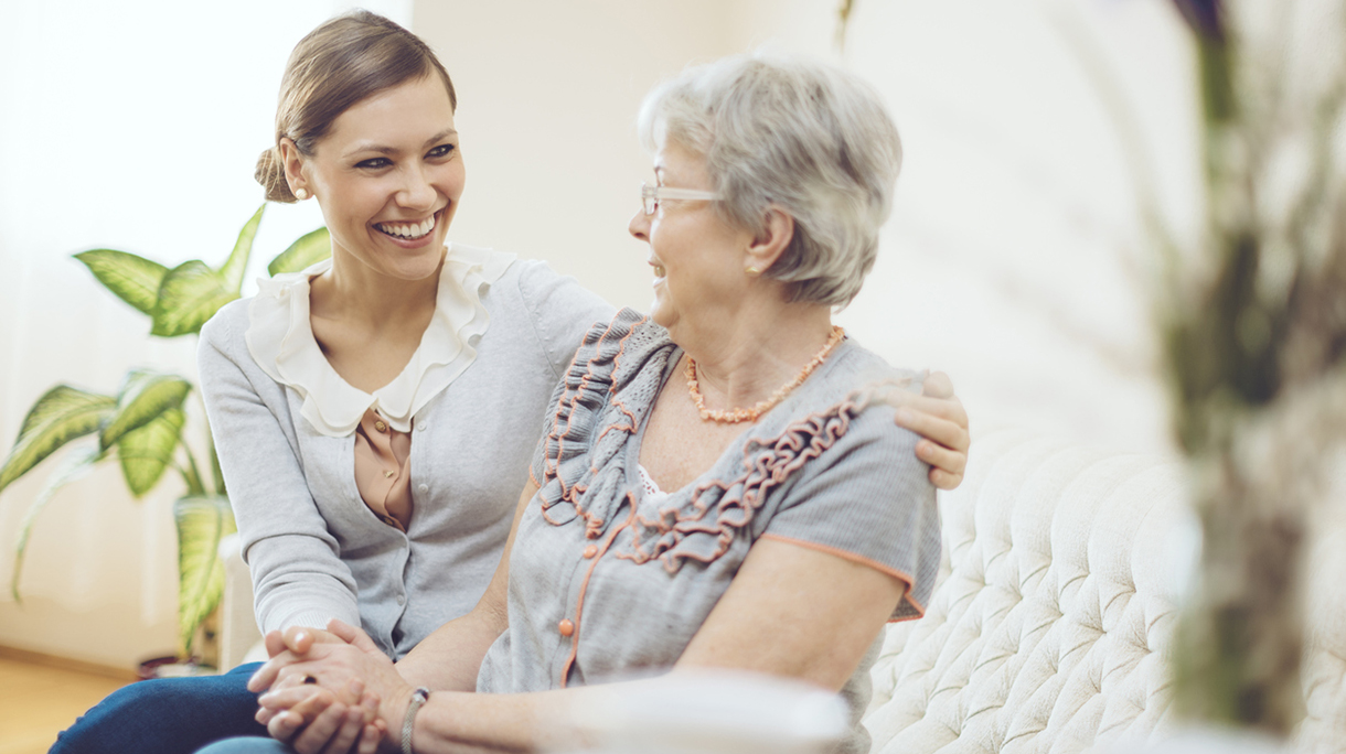 Young social worker is visiting a senior woman at home