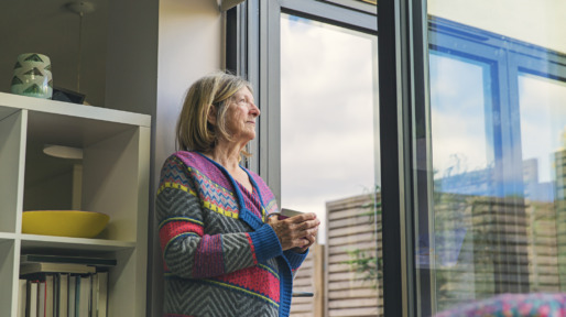 Gas en stroom besparen oudere vrouw kijkt uit het raam