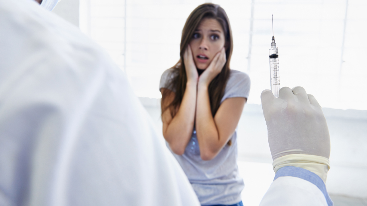 Vrouw met prikangst bij een arts voor het halen van een vaccin