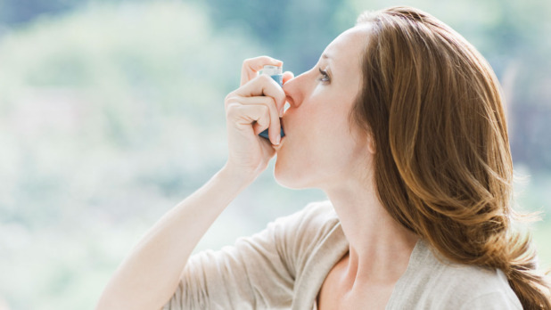 Dame met astma inhalator