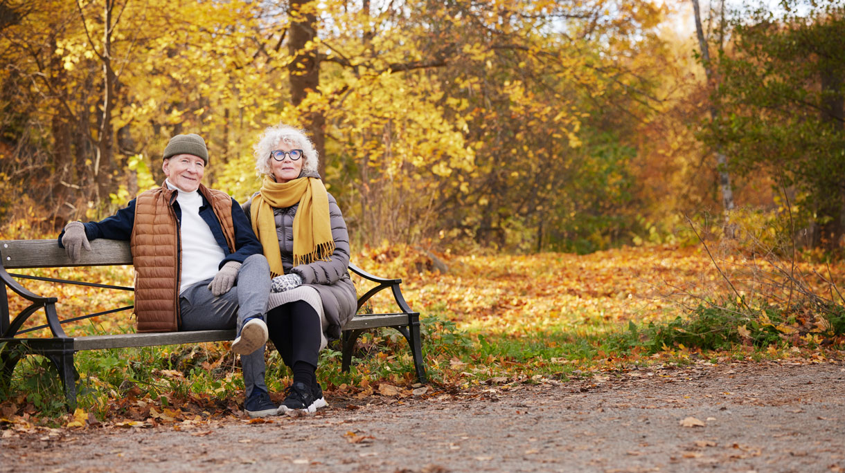 senior stel op bank in het park in de herfst