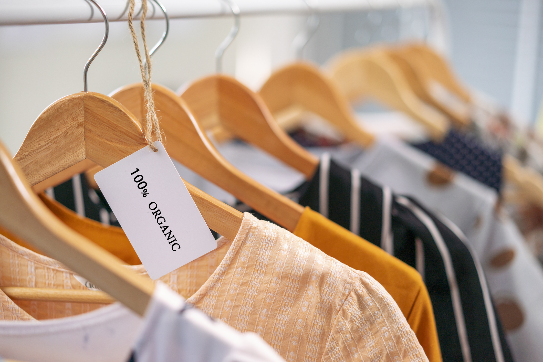 Groen label kledingrek met kledinghangers en kledingstukken