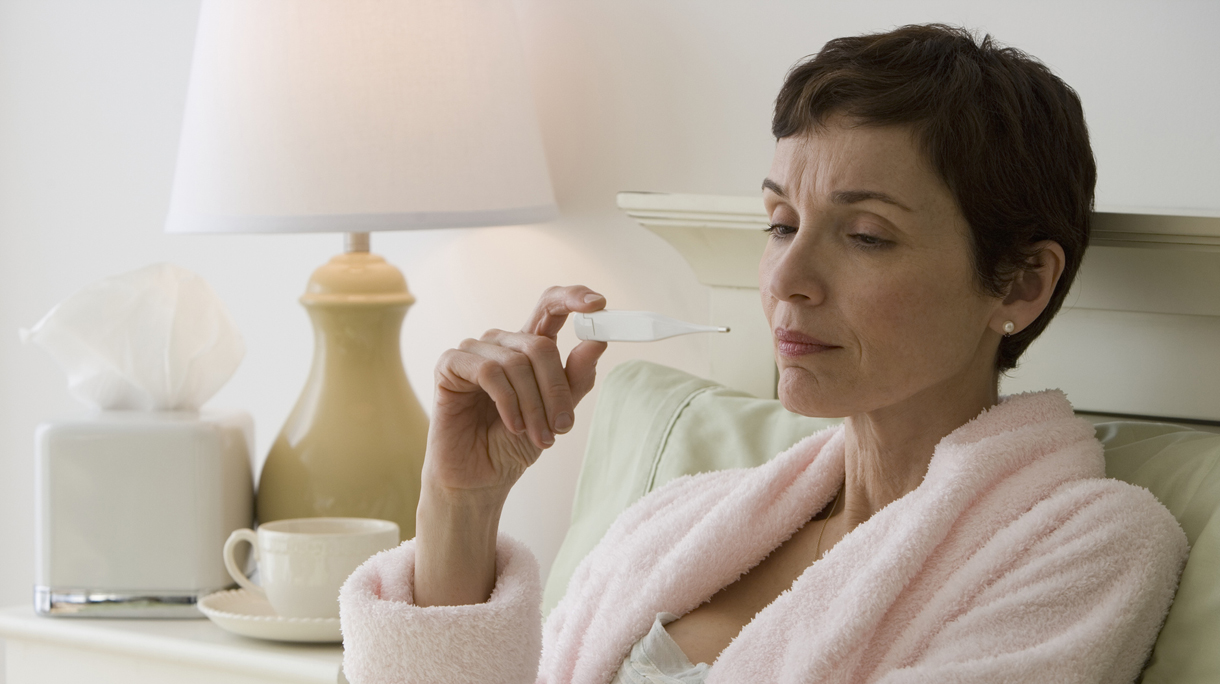oudere vrouw kijkt naar thermometer