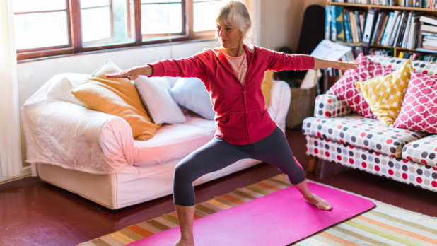 Oudere dame doet aan yoga in kleurrijke yoga kamer