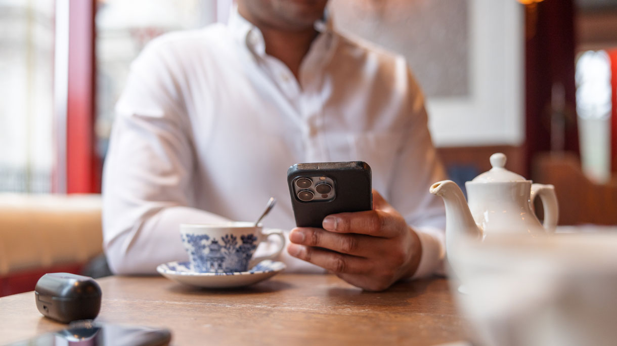 man aan tafel gebruikt iPhone
