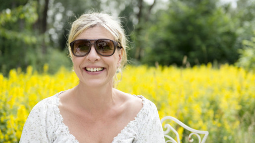 Vrouw met hooikoorts in veld vol bloemen