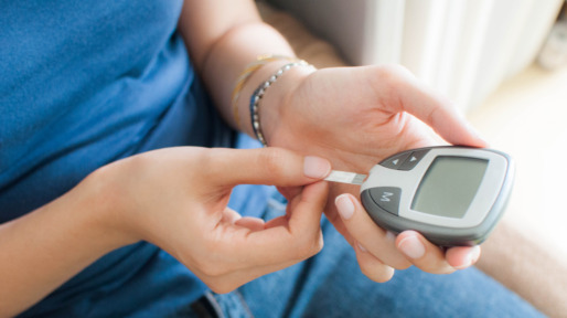 Vrouw meet thuis met glucosemeter