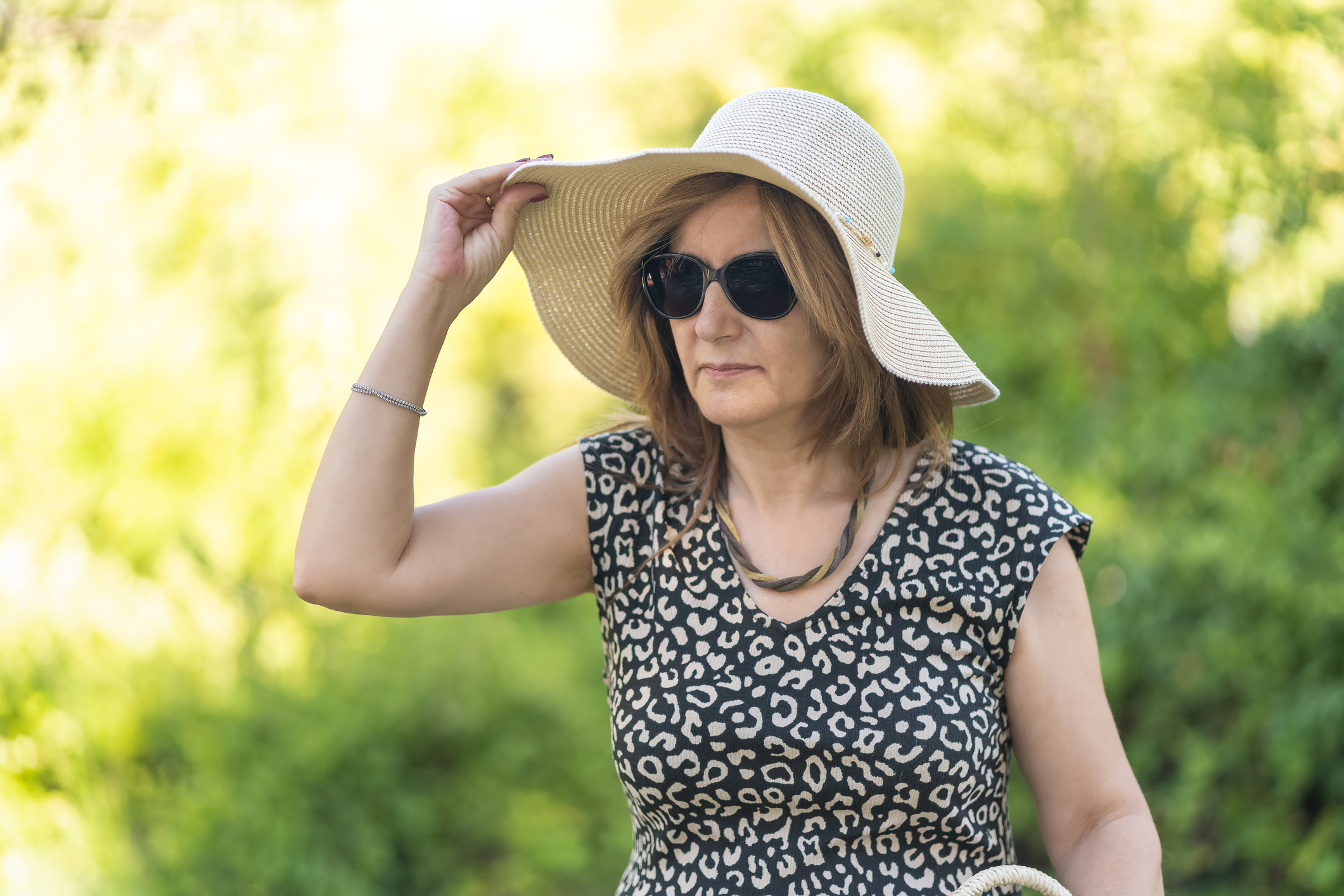 Vrouw met zonnebril en zonnehoed
