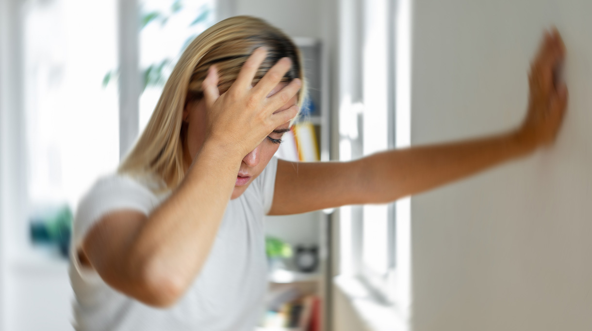 Vrouw met hoofdpijn grijpt haar hoofd vast