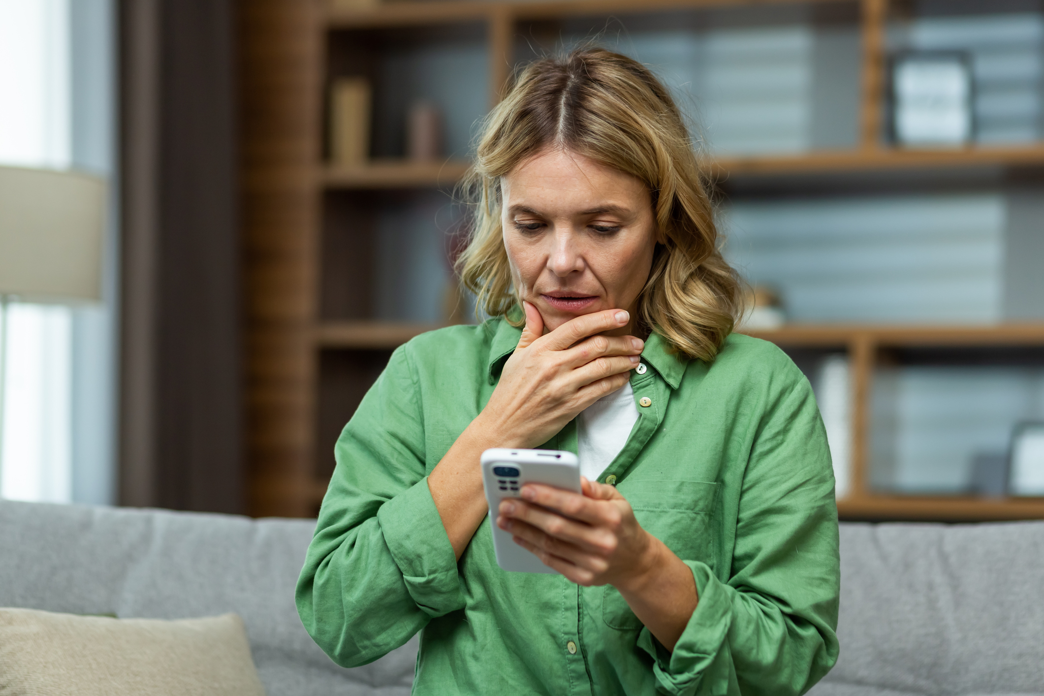 Vrouw kijkt bezorgd op haar telefoon