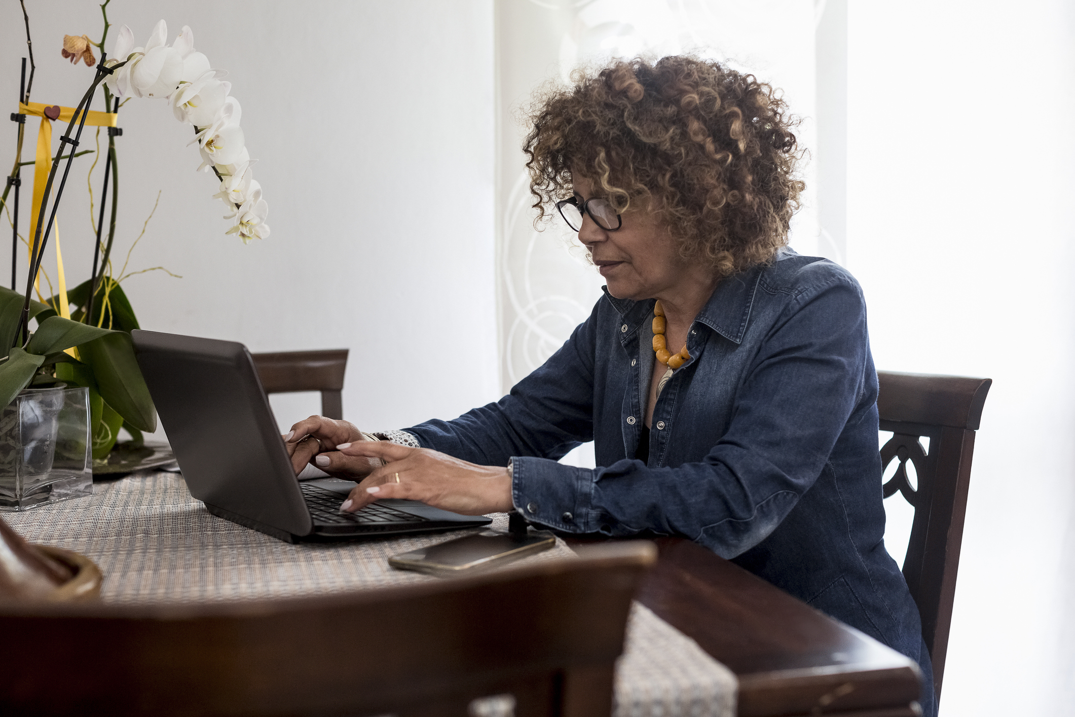 Vrouw met laptop in de woonkamer