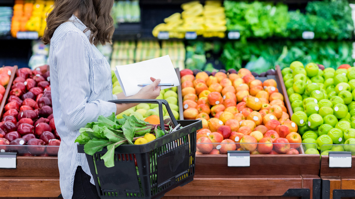 Vrouw op de groente en fruit afdeling in de supermarkt