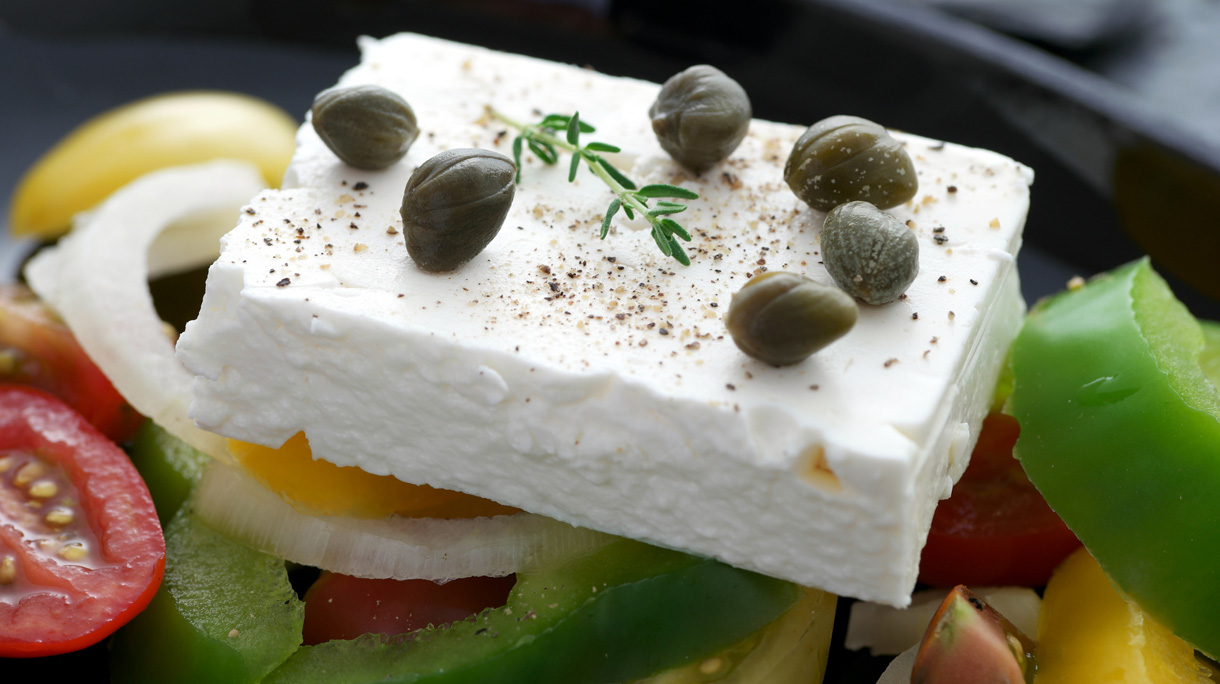 Stuk feta op een Griekse salade met olijven