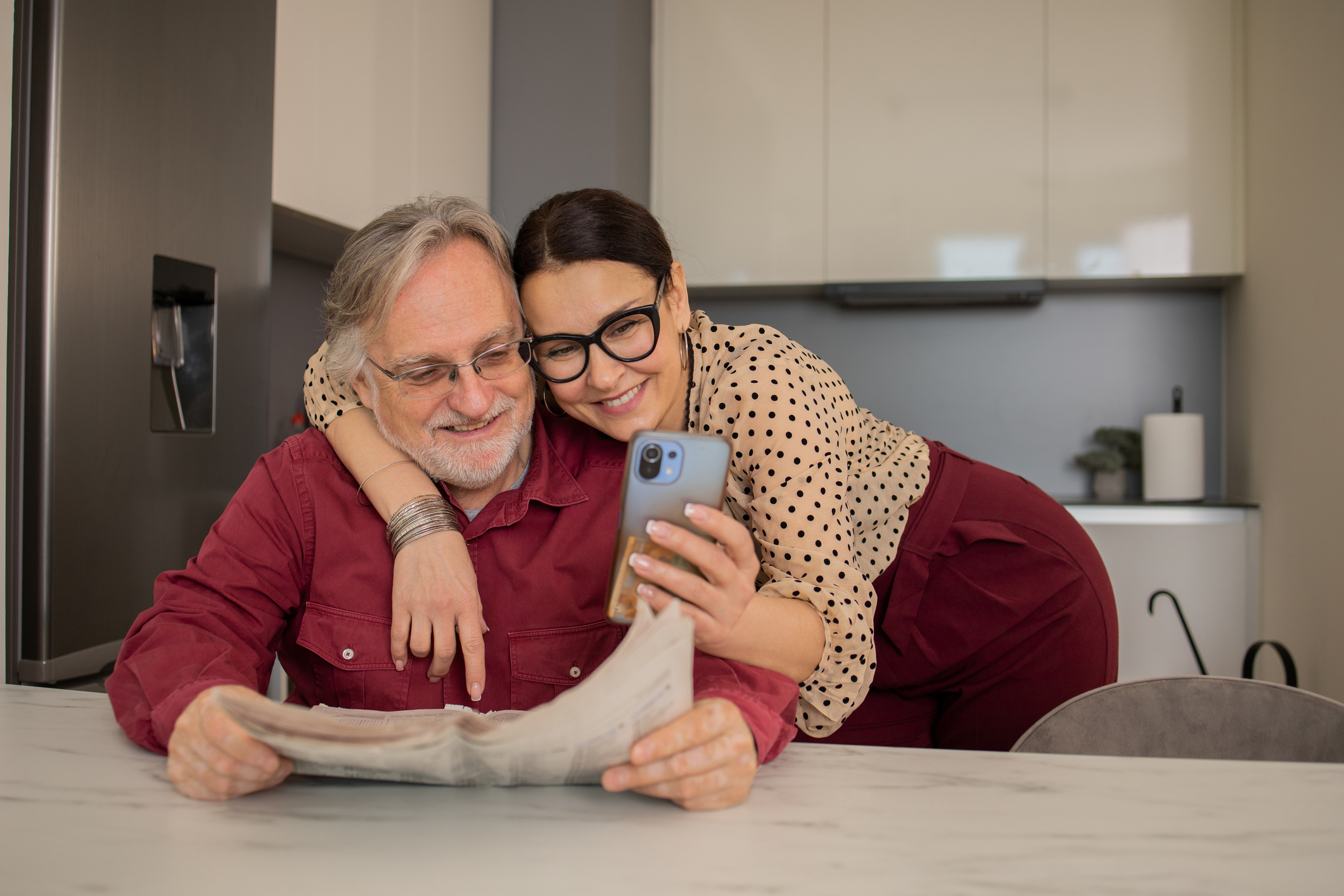 Koppel is bezig met smartphone bekijken in de keuken