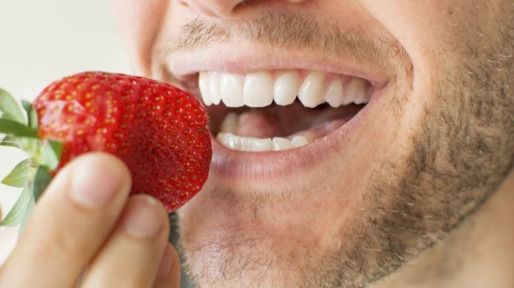 man eet aardbei