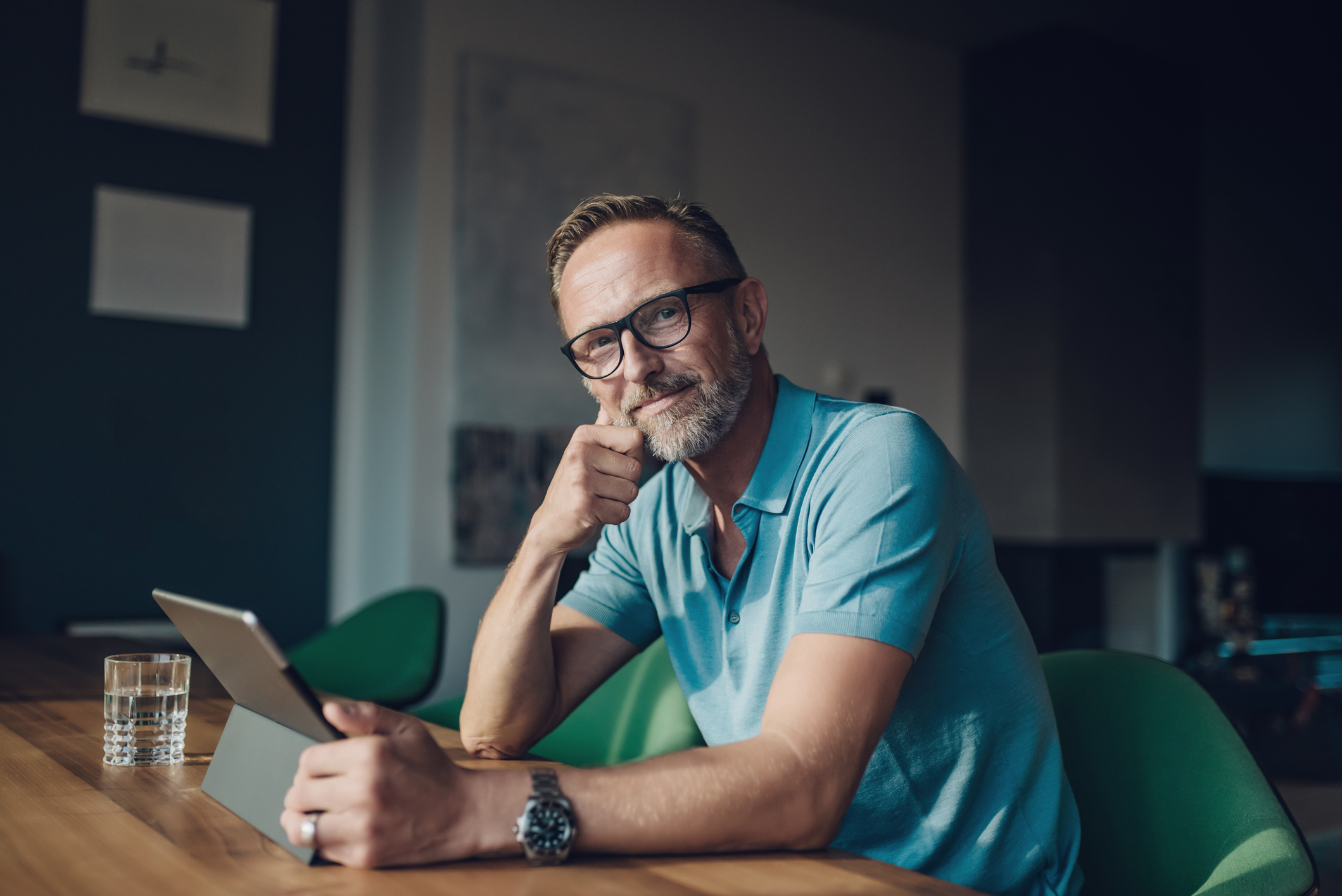 Oudere man aan het werk in zijn studeerkamer, dim licht