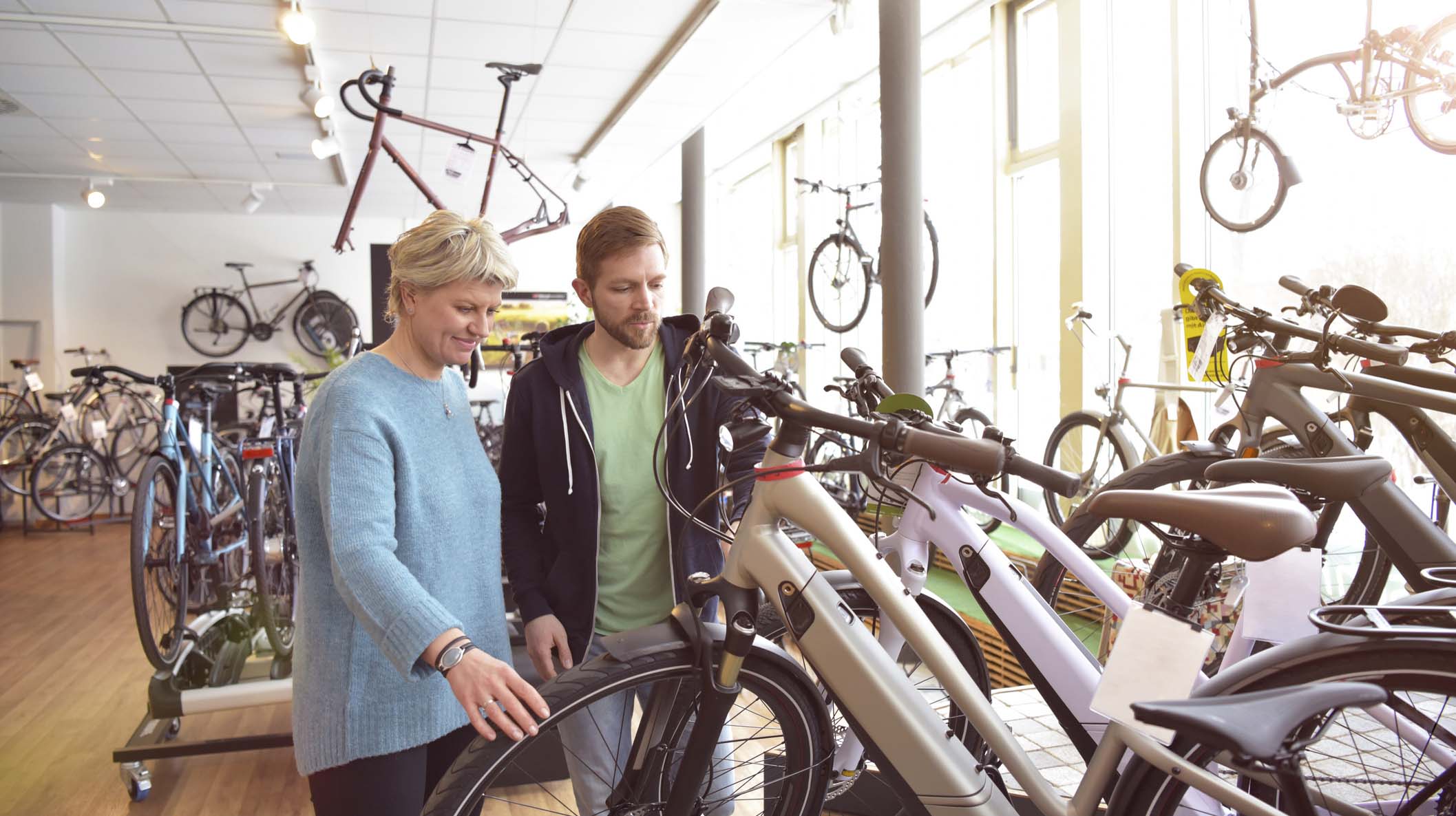 Salesman helping customer with e-bike