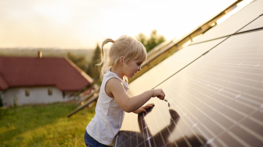 Young girl touching solar panel.