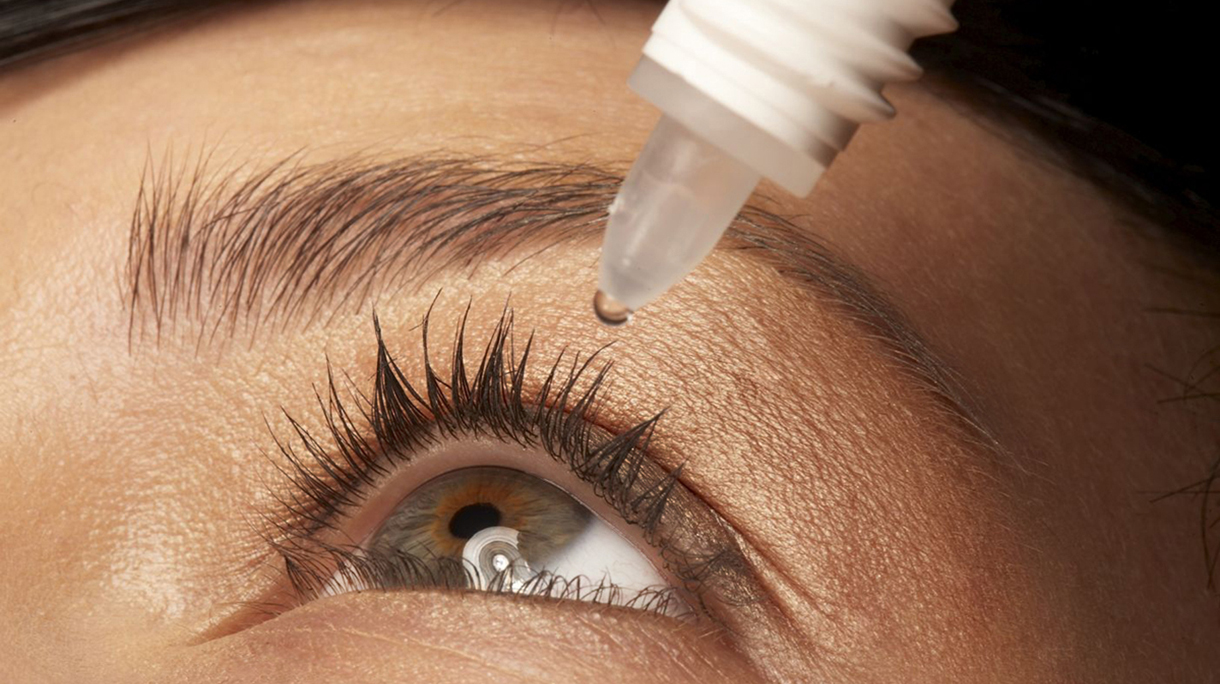 woman putting eye drops in