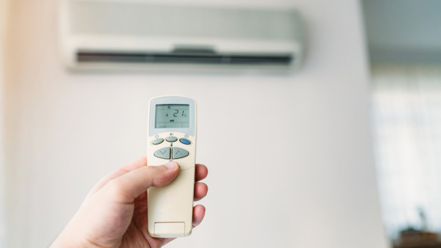 Air conditioner closeup hand with remote control