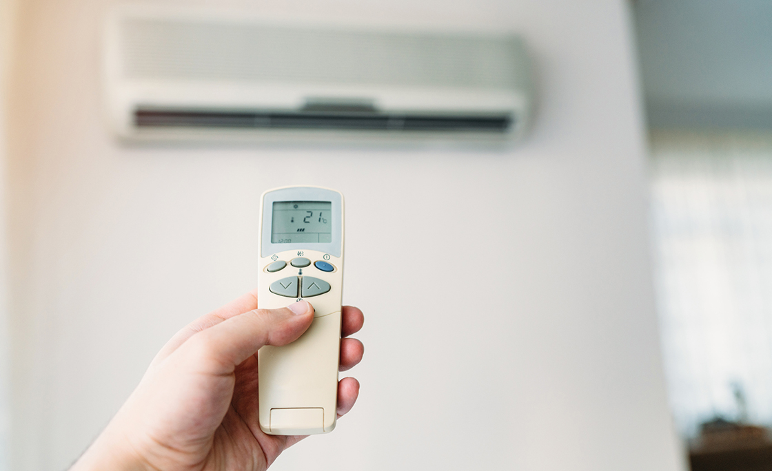 Air conditioner closeup hand with remote control