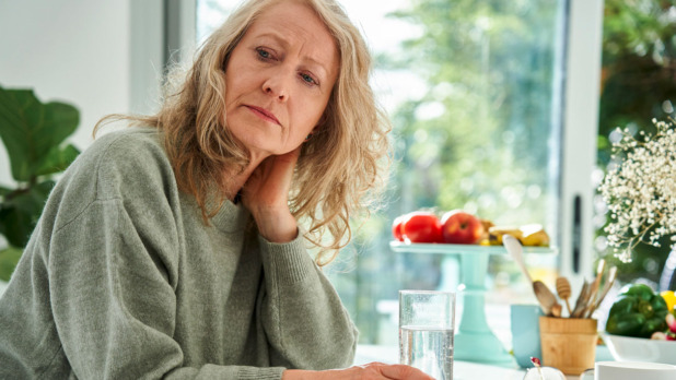 Vrouw kijkt zorgelijk, heeft klachten aan schouders en armen