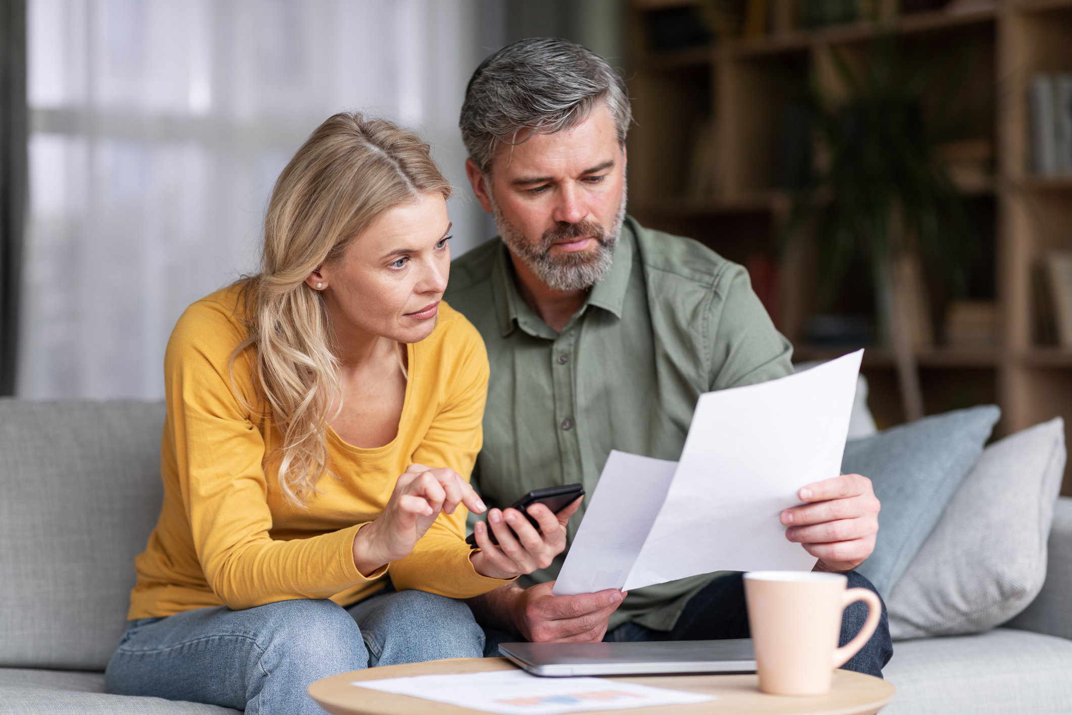 Ouder koppel op de bank met papierenc
