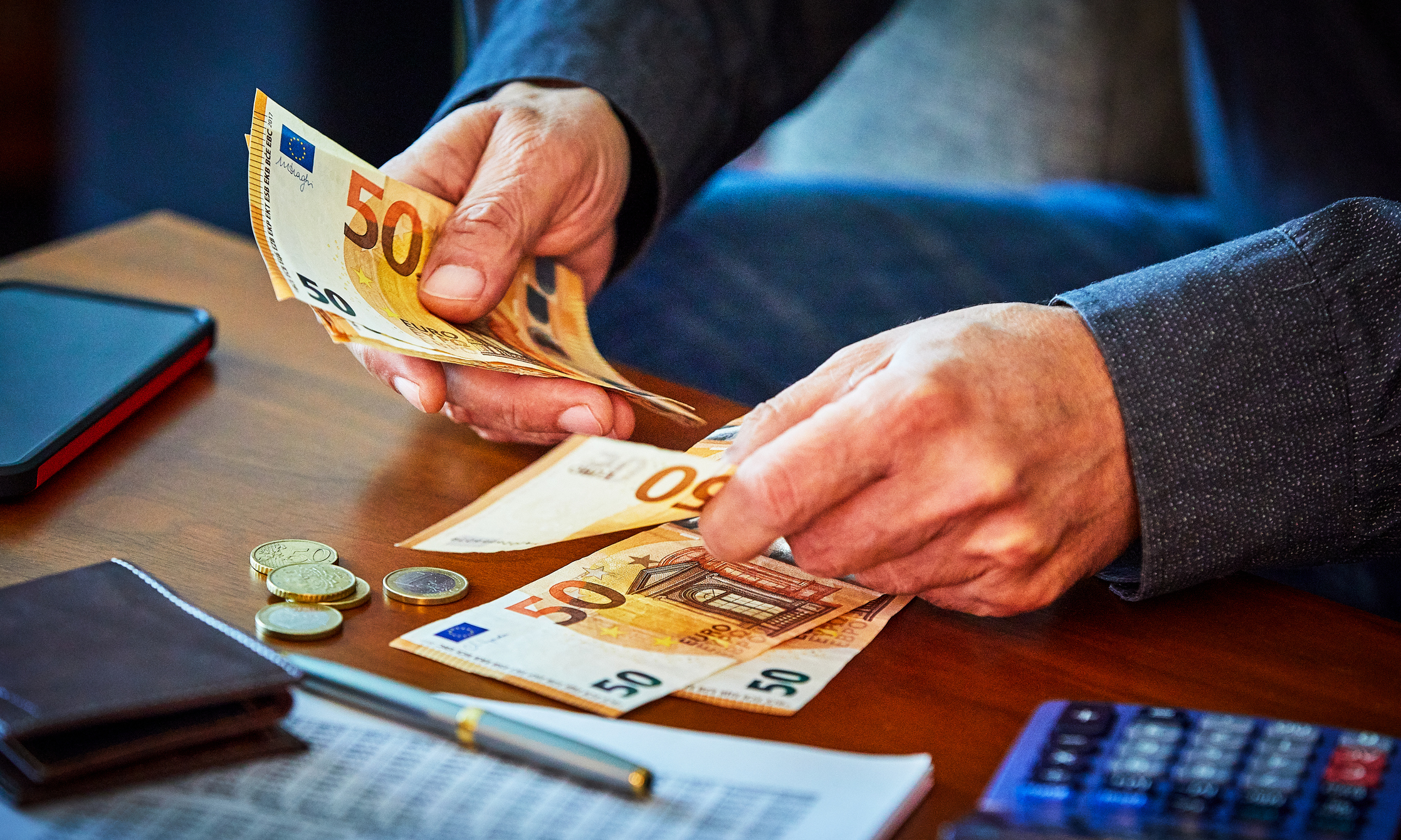 Beleggen en bankbiljetten vasthouden achter de computer