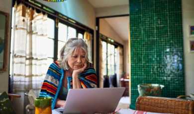 Senior werkt beneden op laptop