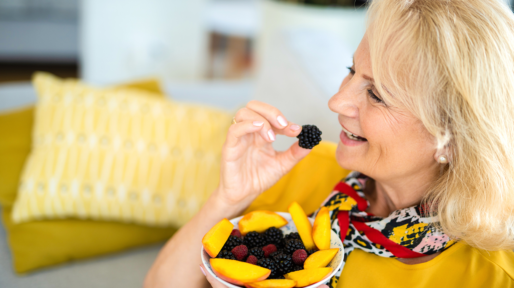 Vrouw eet fruit op de bank