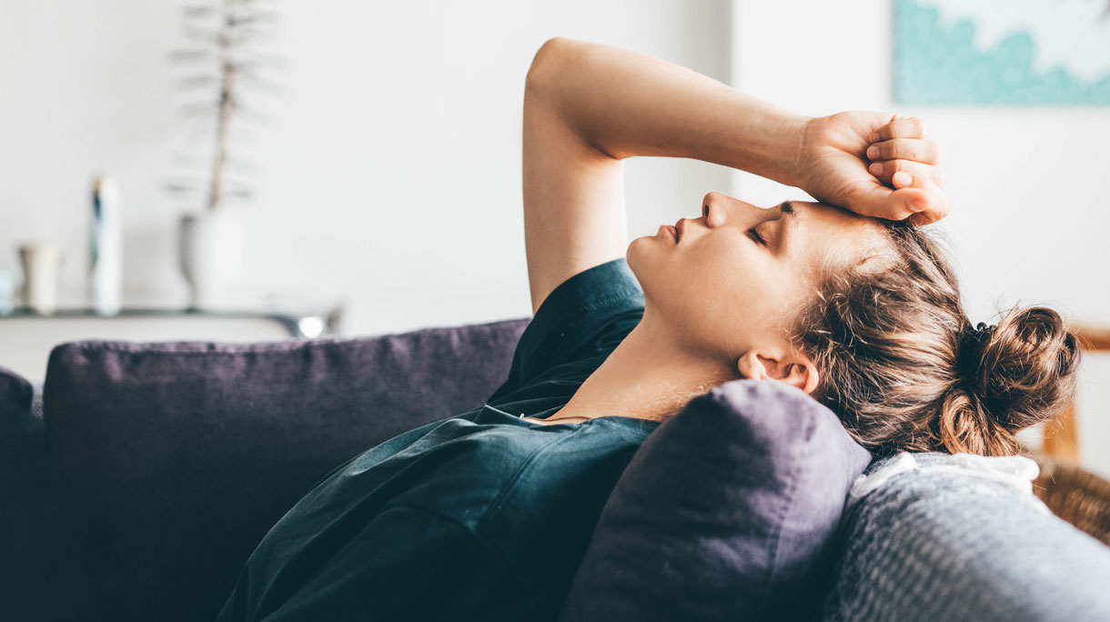 Vrouw ligt gestresst op de bank