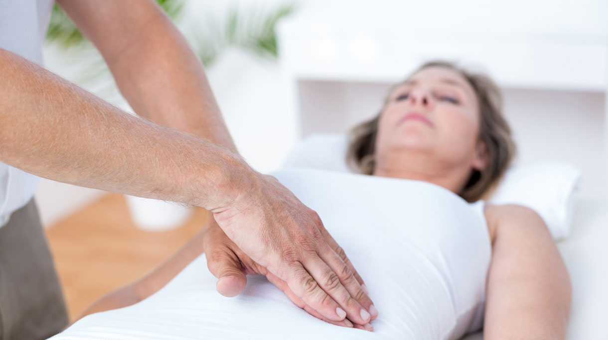 Vrouw ligt op behandeltafel bij de osteopaat