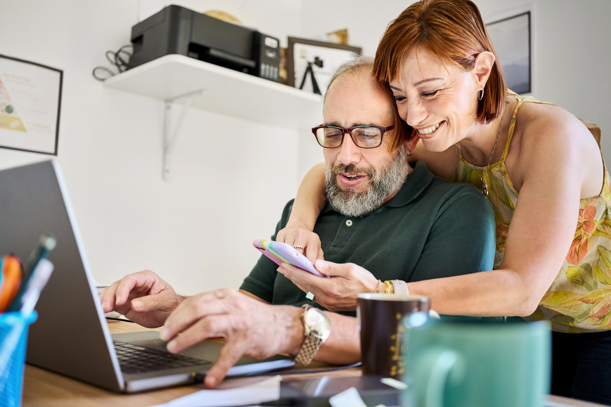 Vrouw en man achter computer en telefoon