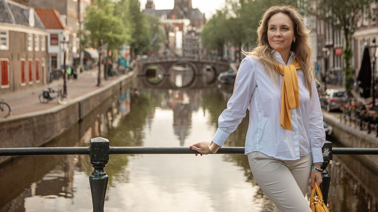 Vrouw op een brug in Amsterdam poserend