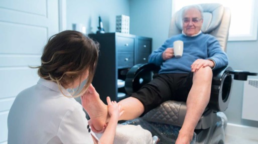 Oudere man zit bij pedicure