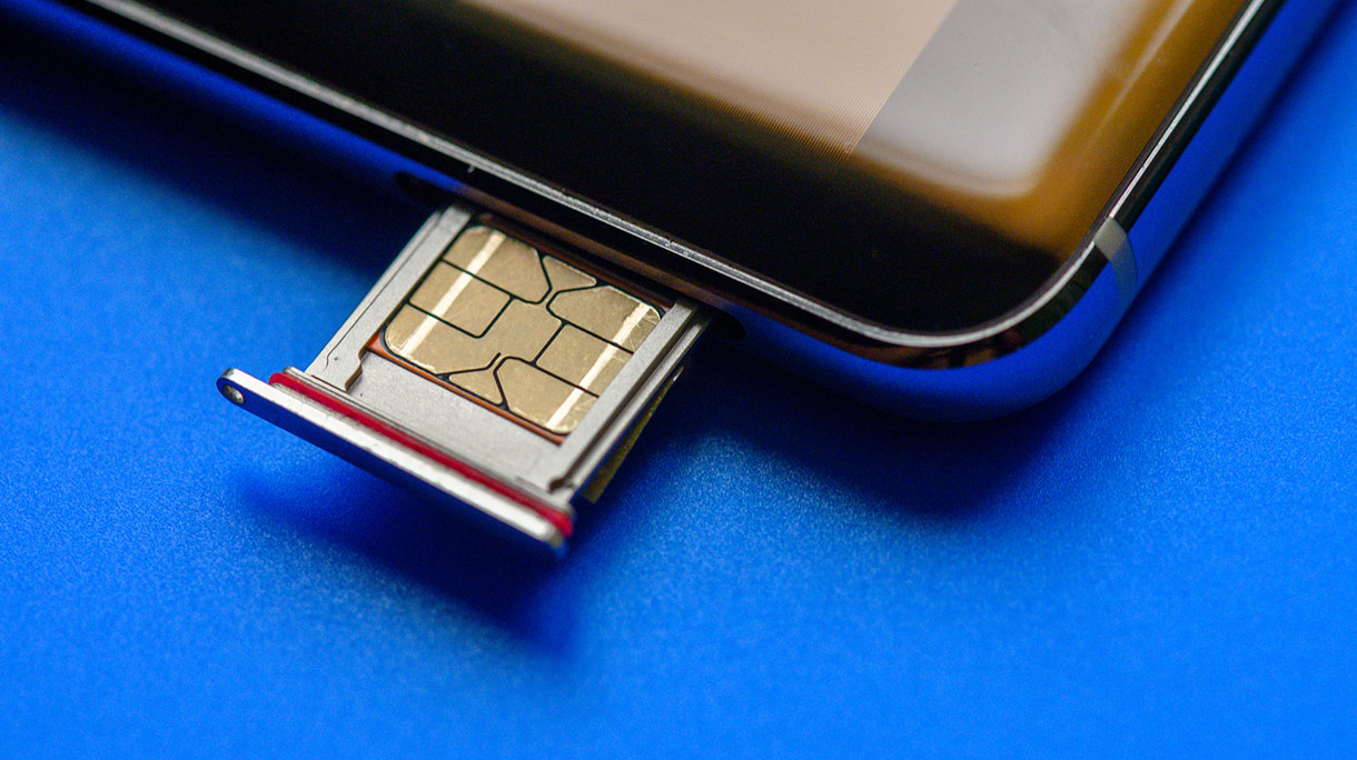 Smart phone and sim card on blue background