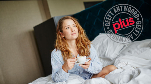 Vrouw wordt wakker met kop koffie op bed