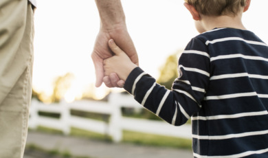 Vader houdt hand van zoon vast