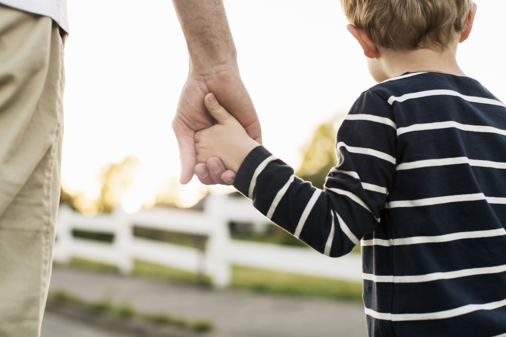 Vader houdt hand van zoon vast