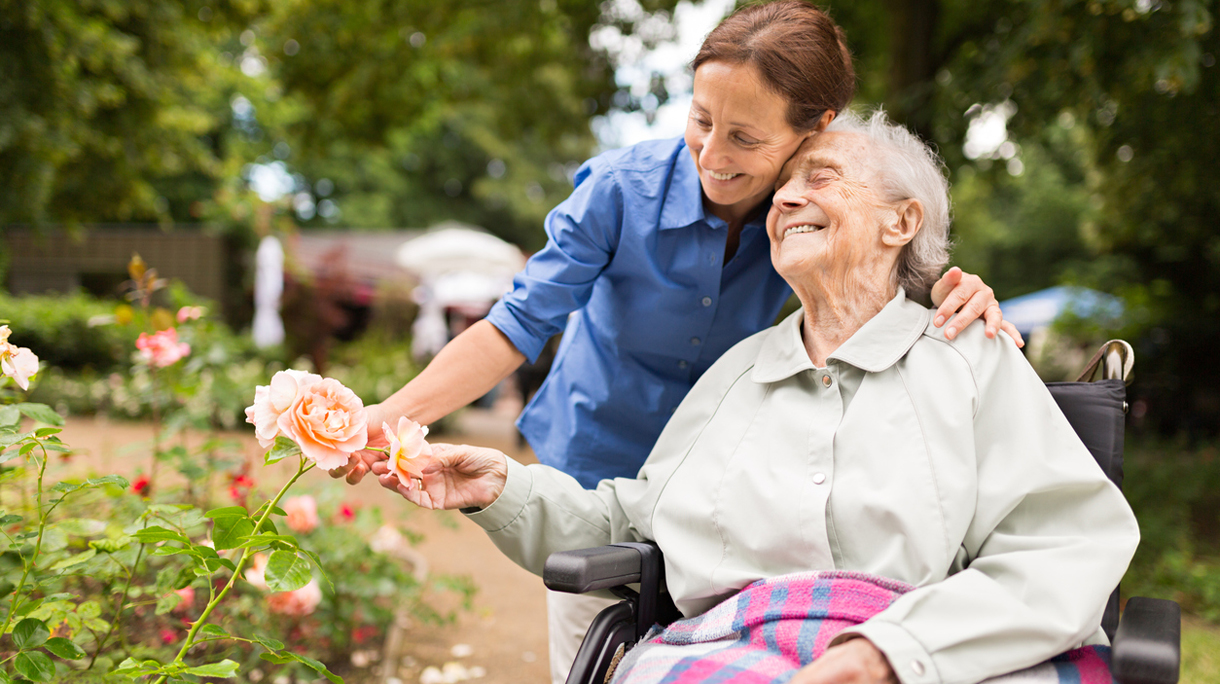 Senior woman sitting on a wheelchair with caregiver
